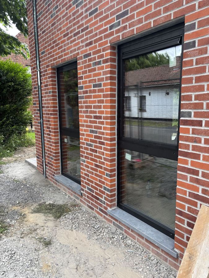 Châssis aluminium noirs sur façade en briques