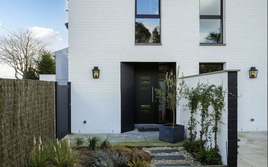 Entrée de maison, façade blanche et menuiseries noires